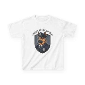 May include: White t-shirt featuring a graphic of a German Shepherd dog in a police uniform and hat. The dog is inside a shield with the text "FUTURE POLICE OFFICER" in a semi-circle above the shield.