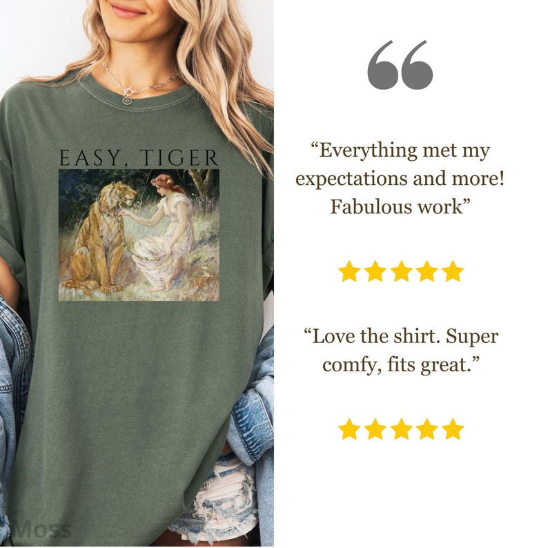 May include: Olive green t-shirt with the text "EASY, TIGER" above a vintage-style image of a woman and a tiger. The shirt has a relaxed fit and is made of soft material. The shirt is a comfortable and stylish choice.