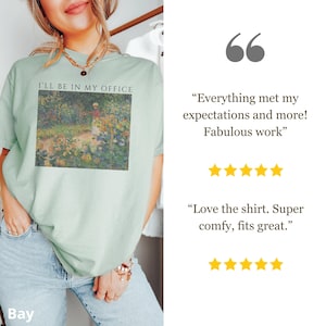 May include: A light green t-shirt with the text "I'LL BE IN MY OFFICE" above a colorful impressionist painting. The shirt is worn by a person. The image also includes customer reviews with five-star ratings.