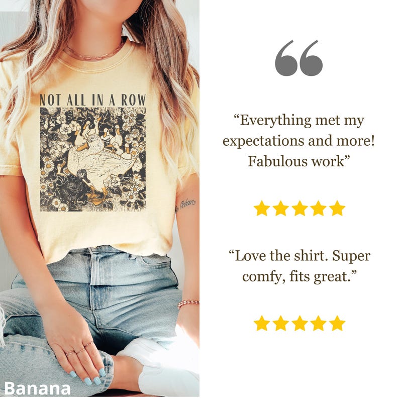 May include: A light yellow t-shirt with the text "NOT ALL IN A ROW" above a graphic of a duck and other birds in a floral design. The shirt is a soft, comfortable material.