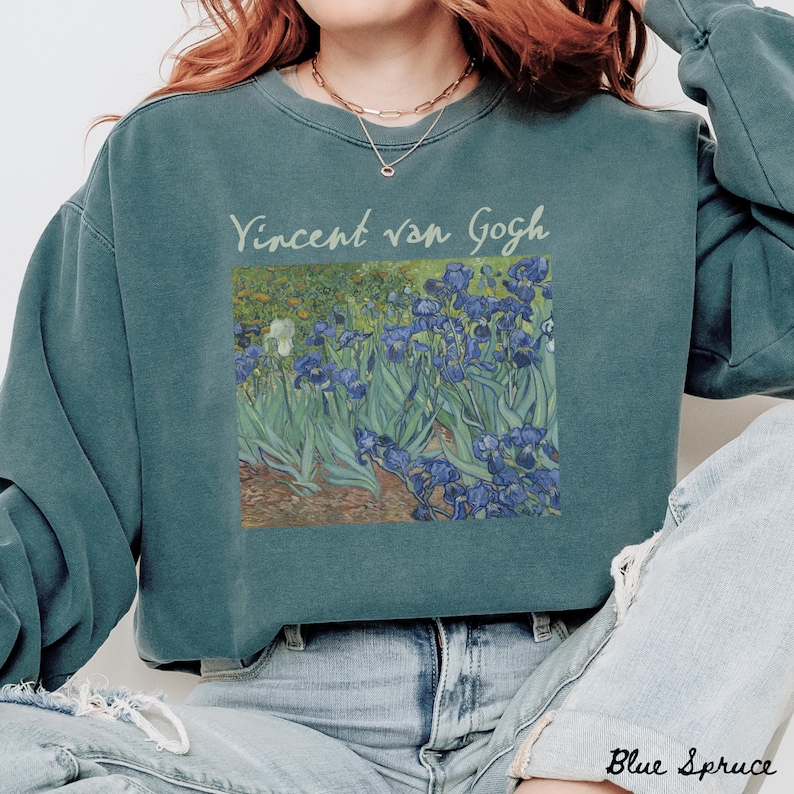 May include: A teal blue sweatshirt with a vintage-style print of Vincent van Gogh's Irises painting. The text "Vincent van Gogh" is printed in white above the painting.
