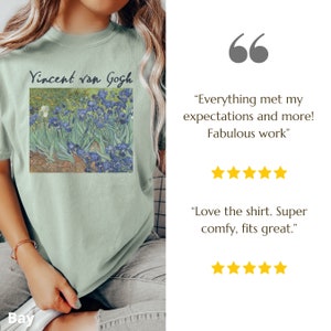 May include: A sage green t-shirt featuring a printed reproduction of Vincent van Gogh's Irises painting with the artist's name in black text above the artwork. The shirt includes two five-star reviews with text quotes about the product quality.