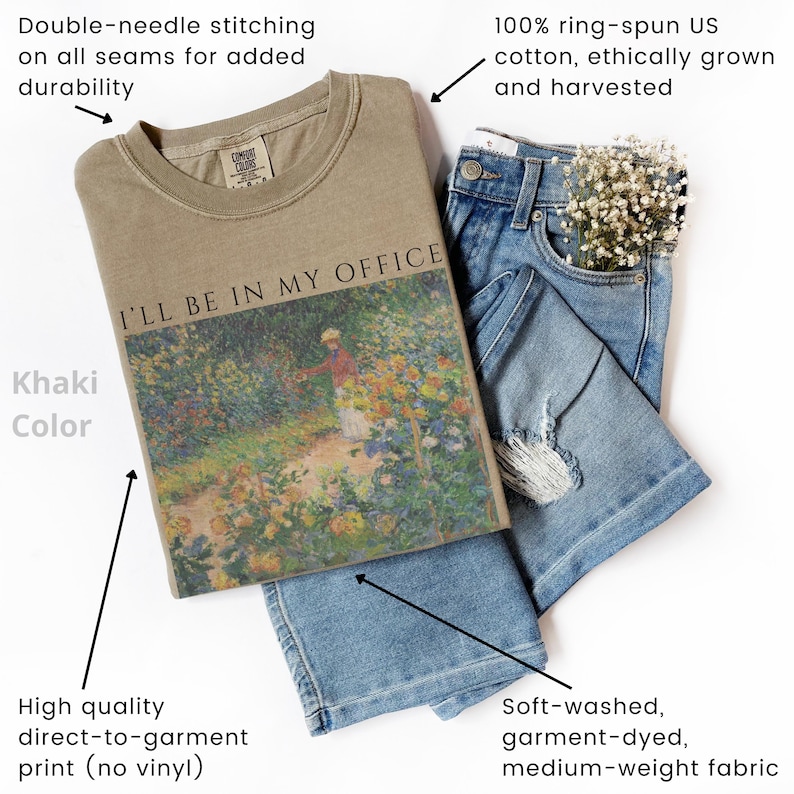 May include: Khaki-colored t-shirt with the text "I'LL BE IN MY OFFICE" and a floral painting. The shirt is paired with blue jeans. Features include double-needle stitching, high-quality direct-to-garment print, and 100% ring-spun US cotton.