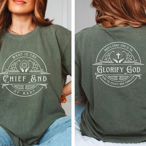 May include: A green t-shirt with a white design on the front and back. The front design says "What is the Chief End of Man?" and the back design says "Man's Chief End is to Glorify God and to Enjoy Him Forever".