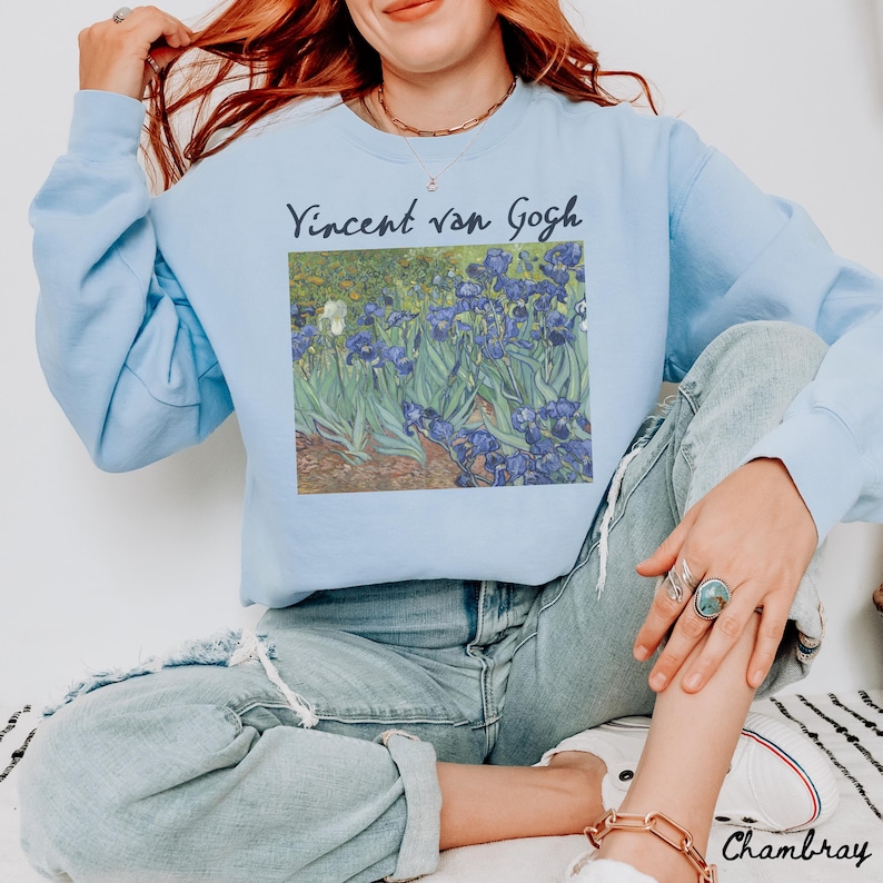 May include: A light blue sweatshirt with a graphic print of Vincent van Gogh's Irises painting. The text "Vincent van Gogh" is printed above the painting.