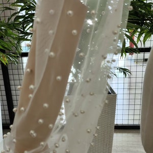 Peut inclure: Tissu blanc transparent avec des perles. Le tissu est drap&eacute; sur un panier en osier blanc.