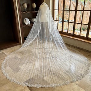 Puede incluir: Un velo de novia blanco con un delicado borde de encaje y un borde festoneado. El velo est&aacute; hecho de tul suave y est&aacute; dise&ntilde;ado para fluir con gracia detr&aacute;s de la novia.