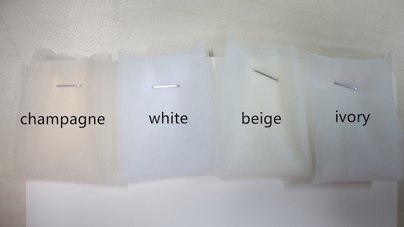 Puede incluir: Cuatro muestras de tejido de tul en diferentes tonos de blanco: champ&aacute;n, blanco, beige y marfil.