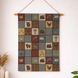 May include: A patchwork wall hanging with a rural theme, showcasing farm animals and countryside elements. The design incorporates squares with illustrations of chickens, cows, sheep, and barns. The color scheme includes brown, blue, and red hues, giving a rustic feel. It hangs from a wooden rod.