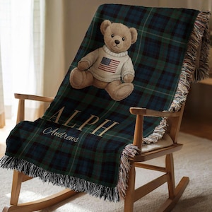 A teddy bear wearing a sweater with an American flag is sitting on a wooden rocking chair.