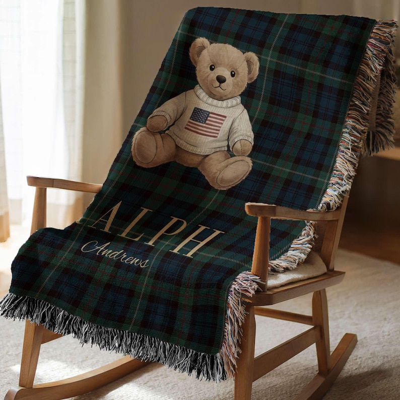 A teddy bear wearing a sweater with an American flag is sitting on a wooden rocking chair.