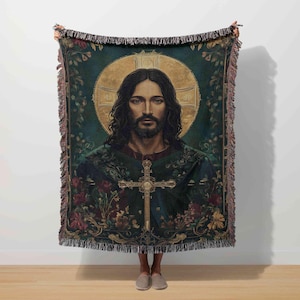 Könnte beinhalten: Eine Wandteppich-Wurfdecke mit einem Porträt eines Mannes mit langen dunklen Haaren, Bart und Kreuz. Das Porträt ist vor einem goldenen Heiligenschein platziert und von floralen Mustern in Grün, Rot und Gold umgeben. Die Decke hat einen Fransenrand.