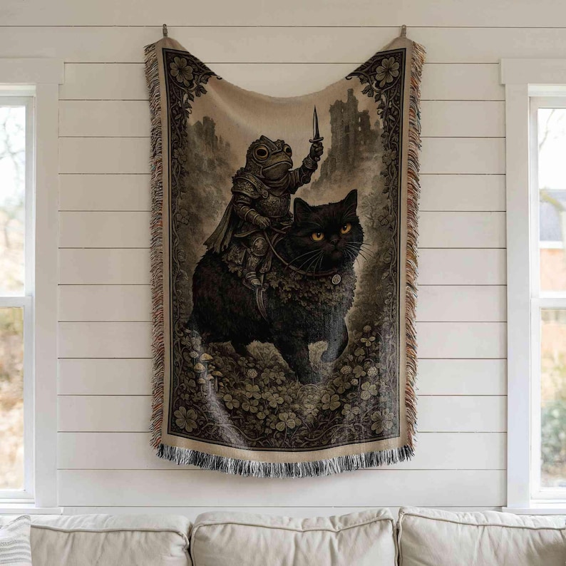 a tapestry hanging on a wall, depicting a frog riding a cat.