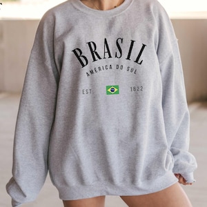 a woman wearing a gray sweatshirt and shorts