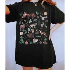 a woman wearing a black shirt with animals on it