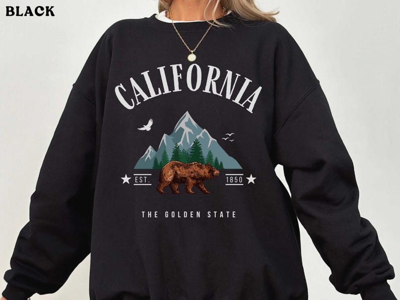 a woman wearing a black sweatshirt with a bear on it