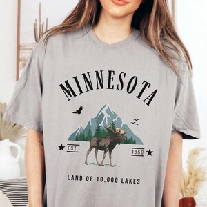 a woman wearing a minnesota t - shirt with a moose on it