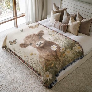 a cozy bedroom scene with a large bed adorned with a blanket featuring a cow surrounded by flowers and butterflies.