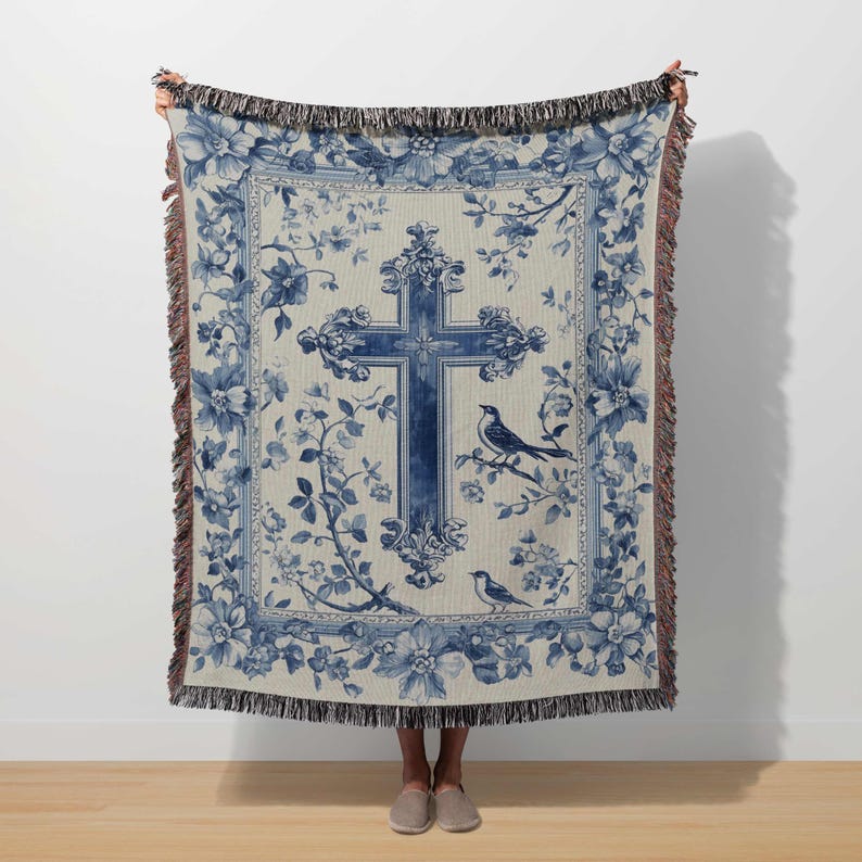 a woman holding a blue and white tapestry with a cross on it