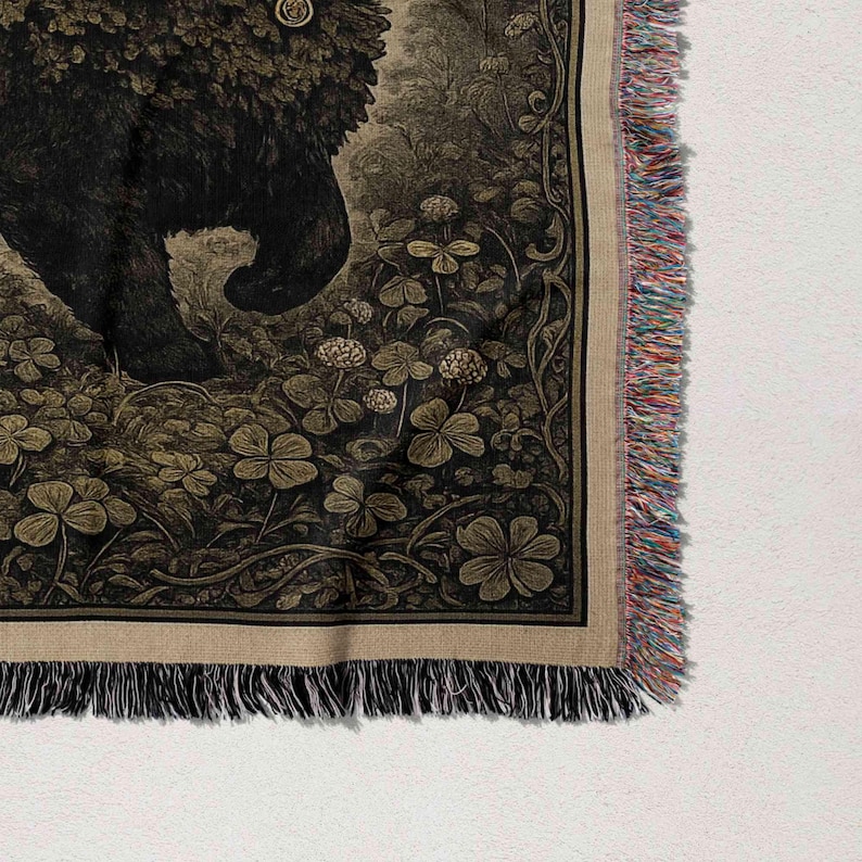 a close-up view of a detailed tapestry or textile with a floral pattern and a fringed edge.
