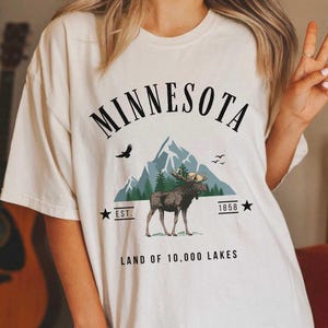 a woman wearing a minnesota t - shirt with a moose on it