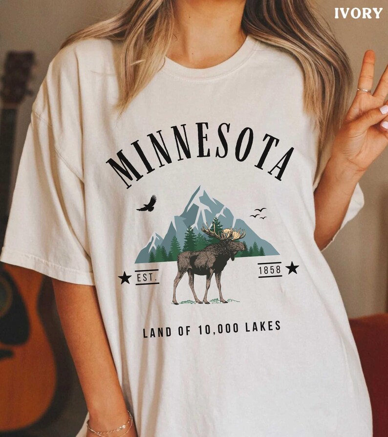 a woman wearing a minnesota t - shirt with a moose on it