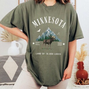 a woman wearing a minnesota t - shirt with a moose on it