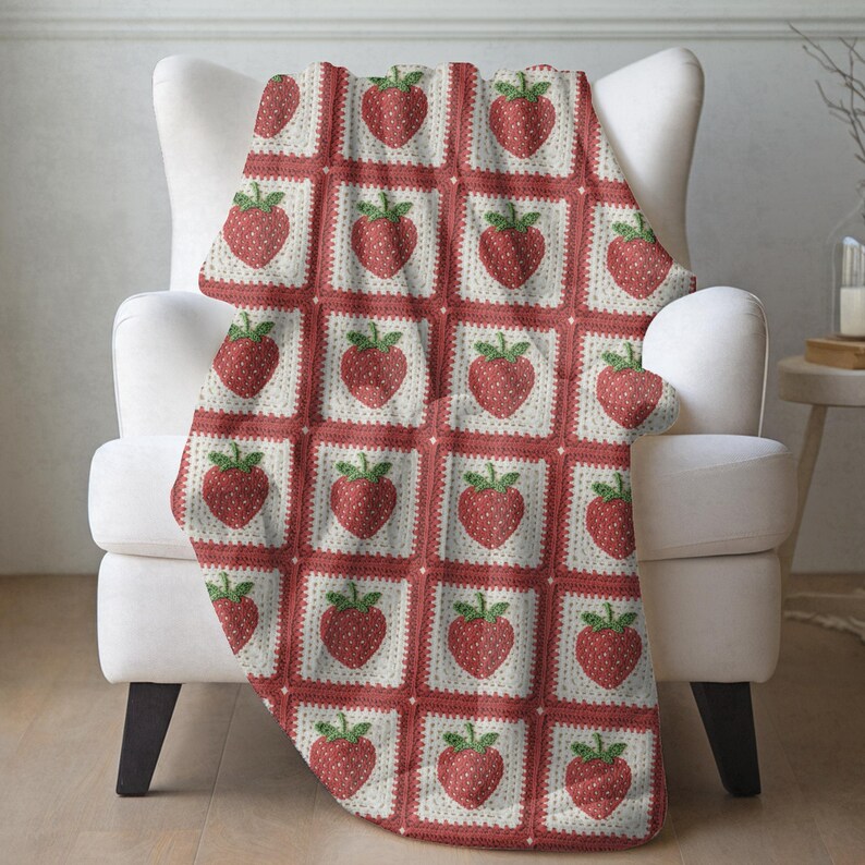a red and white blanket with strawberries on it