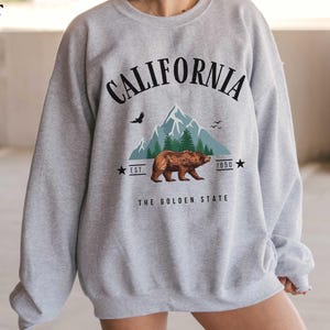 a woman wearing a sweatshirt with a bear on it