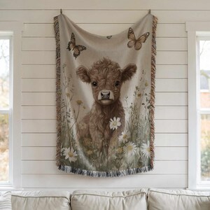 a cow with a floral design hanging on a wall.