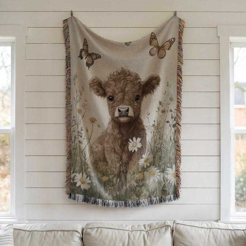 a cow with a floral design hanging on a wall.