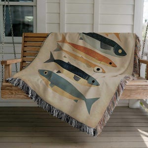 a blanket with fish on it on a porch swing