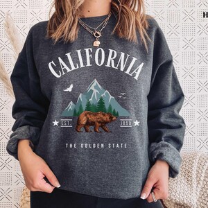 a woman wearing a sweatshirt with a bear on it
