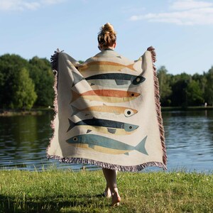 a woman holding a blanket with fish on it