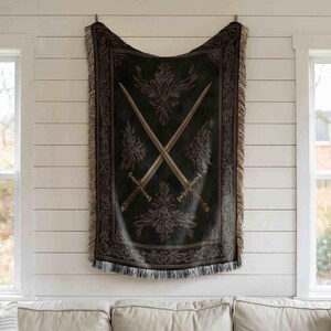 a black and gold tapestry hanging on a white wall, depicting a design with crossed swords.