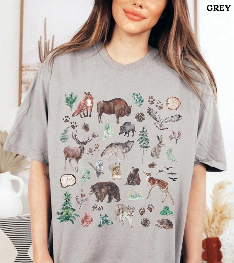 a woman wearing a grey t - shirt with animals on it