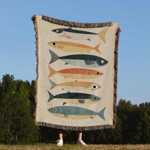 a person standing in front of a tapestry with fish on it