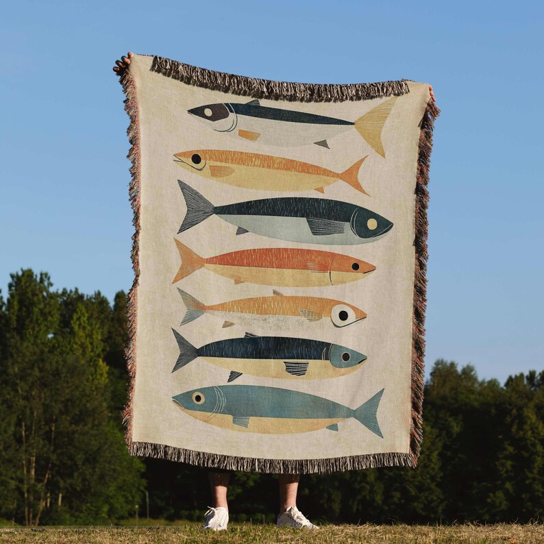 a person standing in front of a tapestry with fish on it