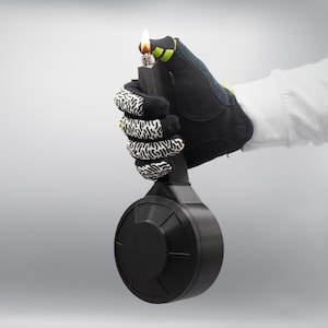 以下が含まれることがあります： 黒と緑の安全フレアに点火されたヒューズが点灯し、黒と白のパターンで手袋に握られています