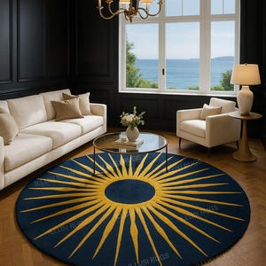 May include: A round, navy blue rug with a gold sunburst design. The rug is in a living room setting with a white sofa, armchair, and a glass-top coffee table. The room has dark walls and a view of the ocean.