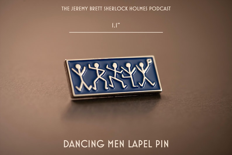Pu&ograve; includere: Una spilla rettangolare con sfondo in smalto blu e cinque figure stilizzate bianche in varie pose di danza. La spilla misura 2,8 cm di larghezza. Il testo riporta THE JEREMY BRETT SHERLOCK HOLMES PODCAST e DANCING MEN LAPEL PIN.