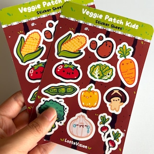 May include: Two sticker sheets featuring colorful vegetable illustrations. Each sticker sheet has a brown background with images of corn, tomatoes, potatoes, lettuce, carrots, and more. The text "Veggie Patch Kids" and "Sticker Sheet" are at the top.
