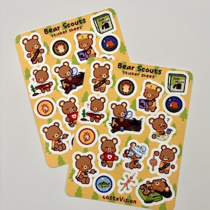 Könnte beinhalten: Zwei Stickerbögen mit gelbem Hintergrund und einem sich wiederholenden Muster aus grünen Bäumen. Jedes Blatt zeigt verschiedene braune Bärenpfadfinder-Aufkleber mit verschiedenen Aktivitäten und dem Text "Bear Scouts sticker sheet".