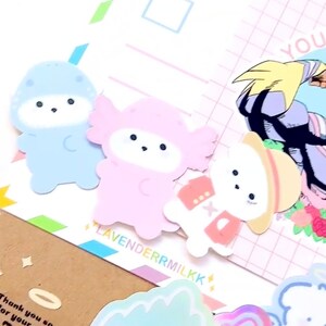 Może przedstawiać: Kolekcja kolorowych naklejek z postaciami z kresk&oacute;wek i ilustracjami w stylu anime. Zawiera naklejkę z napisem "YOU CAN BE A HERO" oraz nazwę marki "LAVENDERRMILKK".