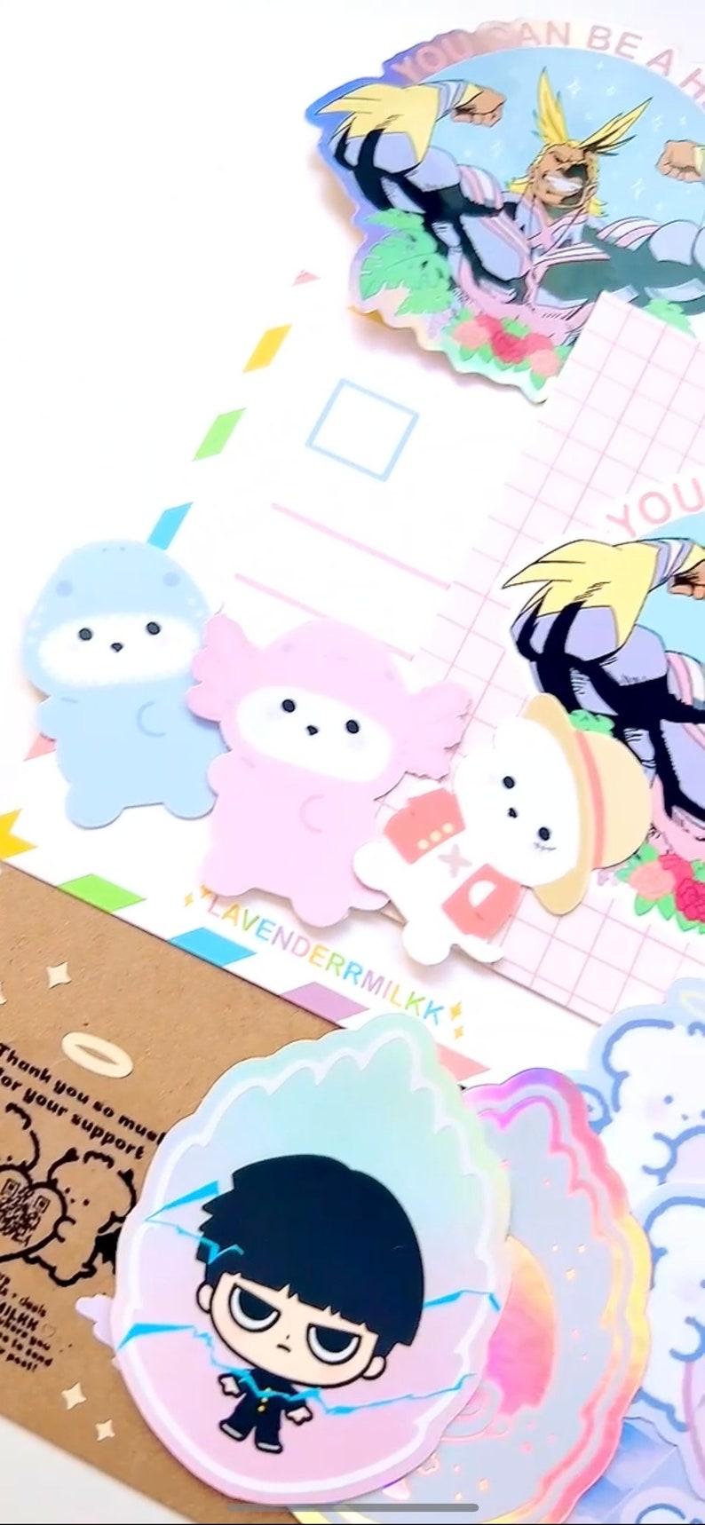 Może przedstawiać: Kolekcja kolorowych naklejek z postaciami z kresk&oacute;wek i ilustracjami w stylu anime. Zawiera naklejkę z napisem "YOU CAN BE A HERO" oraz nazwę marki "LAVENDERRMILKK".