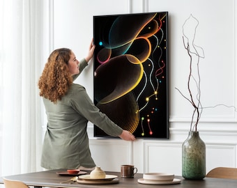 May include: A woman hangs a framed abstract art print on a white wall. The print features colorful lines and shapes on a black background.
