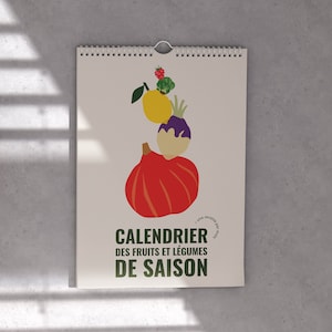 Peut inclure: Un calendrier blanc avec un titre vert qui dit "Calendrier des fruits et légumes de saison". Le calendrier présente une illustration colorée d'une citrouille, d'un citron, d'une aubergine et d'autres fruits et légumes.