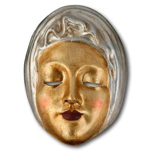 May include: A decorative mask with a serene face, featuring closed eyes and a gentle expression. The face is painted gold with rosy cheeks and a dark red lip color. The mask's head covering is silver, creating a striking contrast.