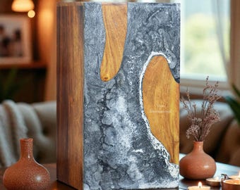 May include: A rectangular wooden block with a gray and gold resin design. The block has a wooden frame and the text "Vovo International" on the side. The block is on a wooden table with candles and small vases.