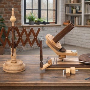 Peut inclure: Un dévidoir à fil et un bobinoir en bois sont présentés sur une table en bois. Le dévidoir est marron et beige, avec un design en accordéon. Le bobinoir est marron et beige, avec une base circulaire et une poignée. L'arrière-plan comprend un mur de briques et une fenêtre.